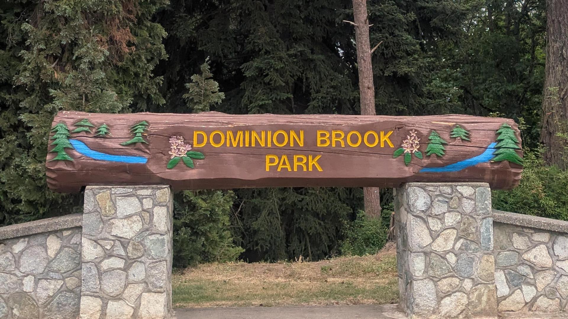 carved wooden park sign on rock pillars.
