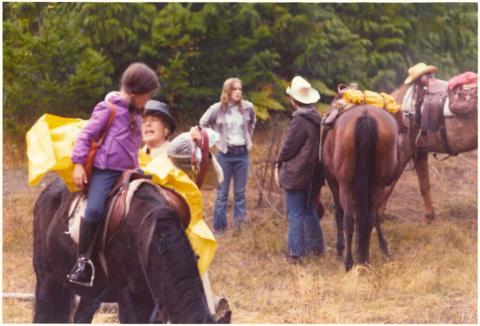 Horses and riders milling around.