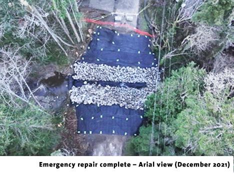Aerial view of a completed emergency repair, featuring a rocky surface and surrounding trees.